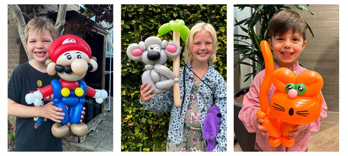 Blije kinderen met ballonfiguur van ballonartiest Pieter